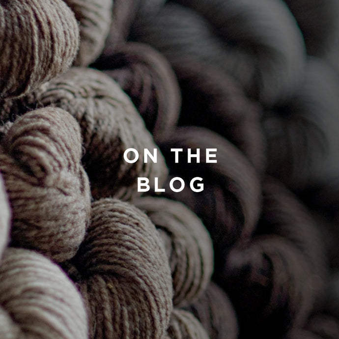 Image of a wall of neutral colored yarn skeins in soft focus. Text overlay button reads: on the blog